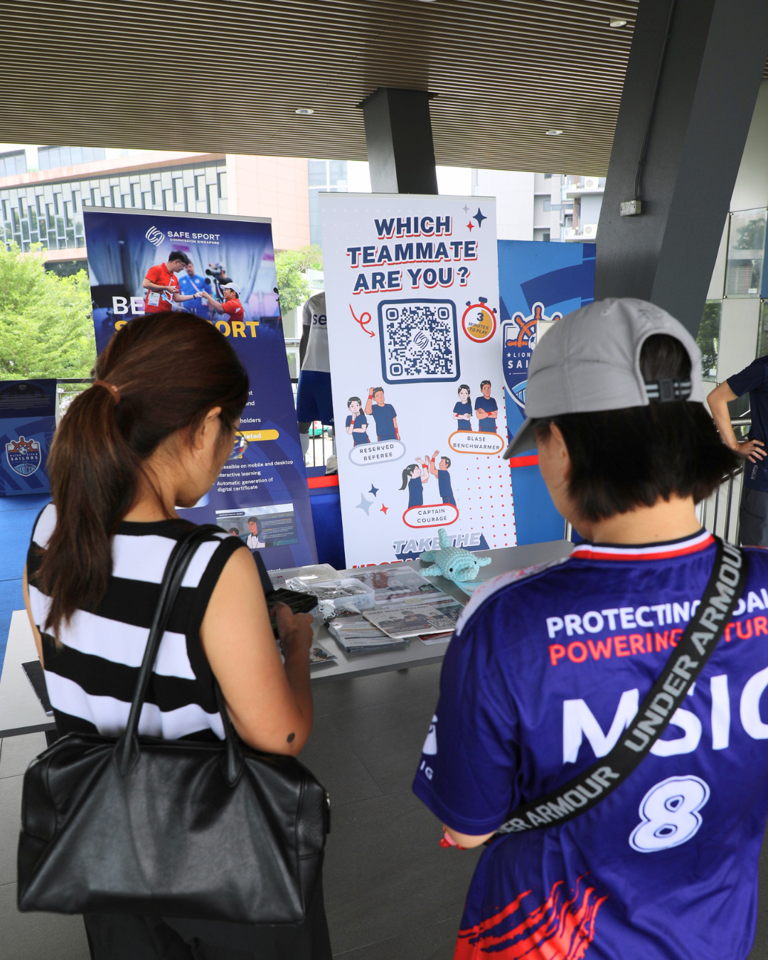 Two adults at the Safe Sport booth, doing the Upstander test